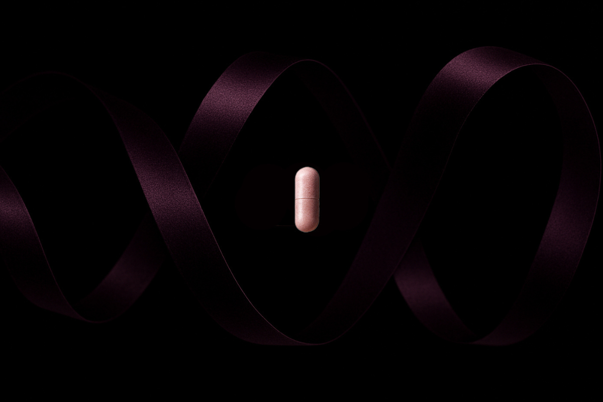 Pink supplement capsules floating with a dark purple ribbon in the background
